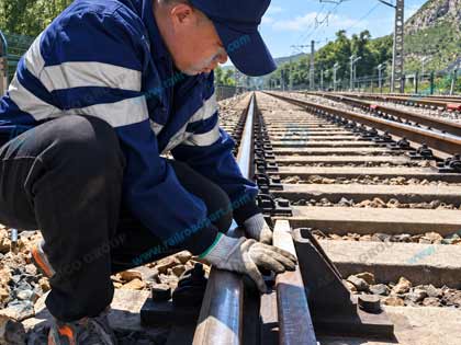 Worker checking check rail bolts and fastening position