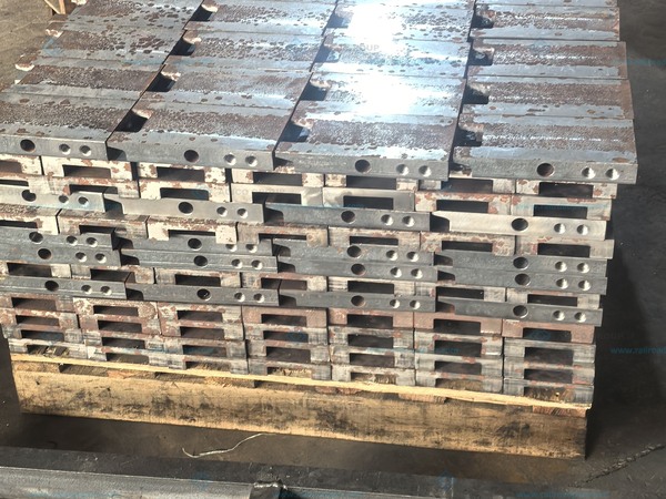 Plate components stacked beside a workshop bench